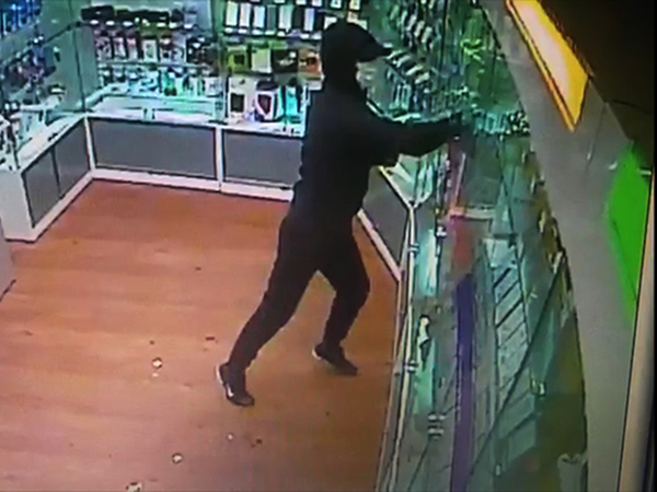 Видео: Небрежный налетчик в маске унес из салона на Пискаревском четыре коробки, а в них — муляжи