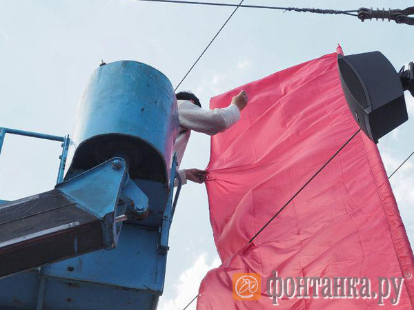 Заплатки на победе. У стрелки Васильевского острова рабочие на высоте штопают красные флаги, Смольный обещает их заменить